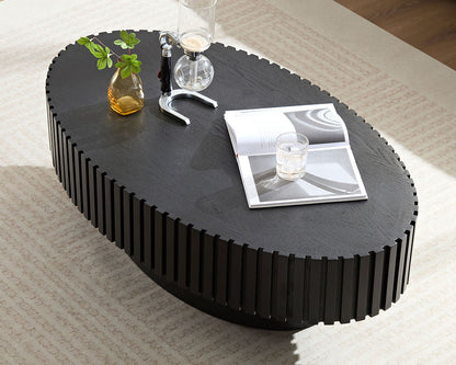 Black coffee table with decorative items on a carpeted floor.